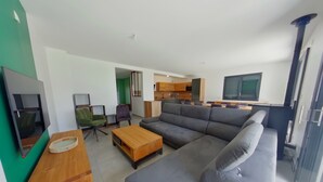A modern living room with a grey sofa, wooden coffee table, and a TV on a stand.