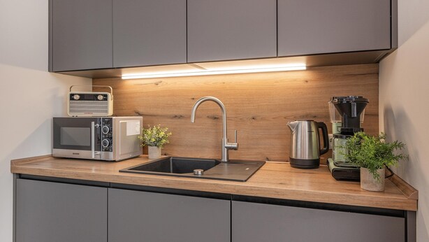 A compact kitchen with a built-in microwave, a kettle, a coffee maker, and a sink. - Welcome to Störtebekers Reethus - your exclusive vacation home on Usedom (Loddin)