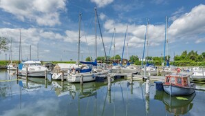 A marina with multiple boats docked, calm water, and a clear sky. - Welcome to Störtebekers Reethus - your exclusive vacation home on Usedom (Loddin)