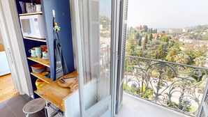 A balcony with a wrought iron railing overlooking a cityscape. - Spacious 3P in quiet palace, sea view in Menton (Menton)
