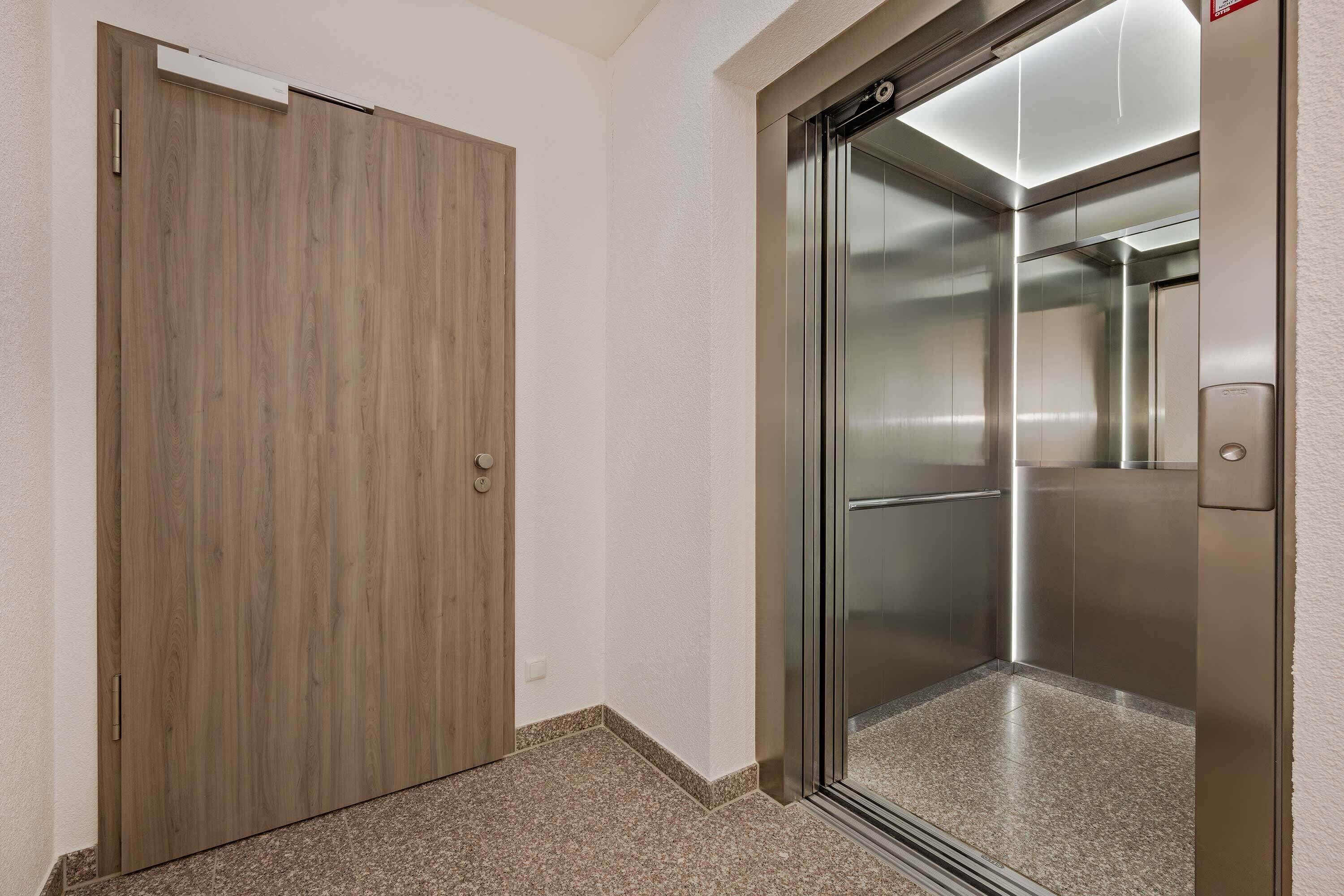 Un ascensor moderno con detalles metálicos y puerta de cristal.