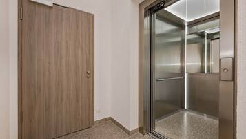 Un ascensor moderno con detalles metálicos y puerta de cristal.