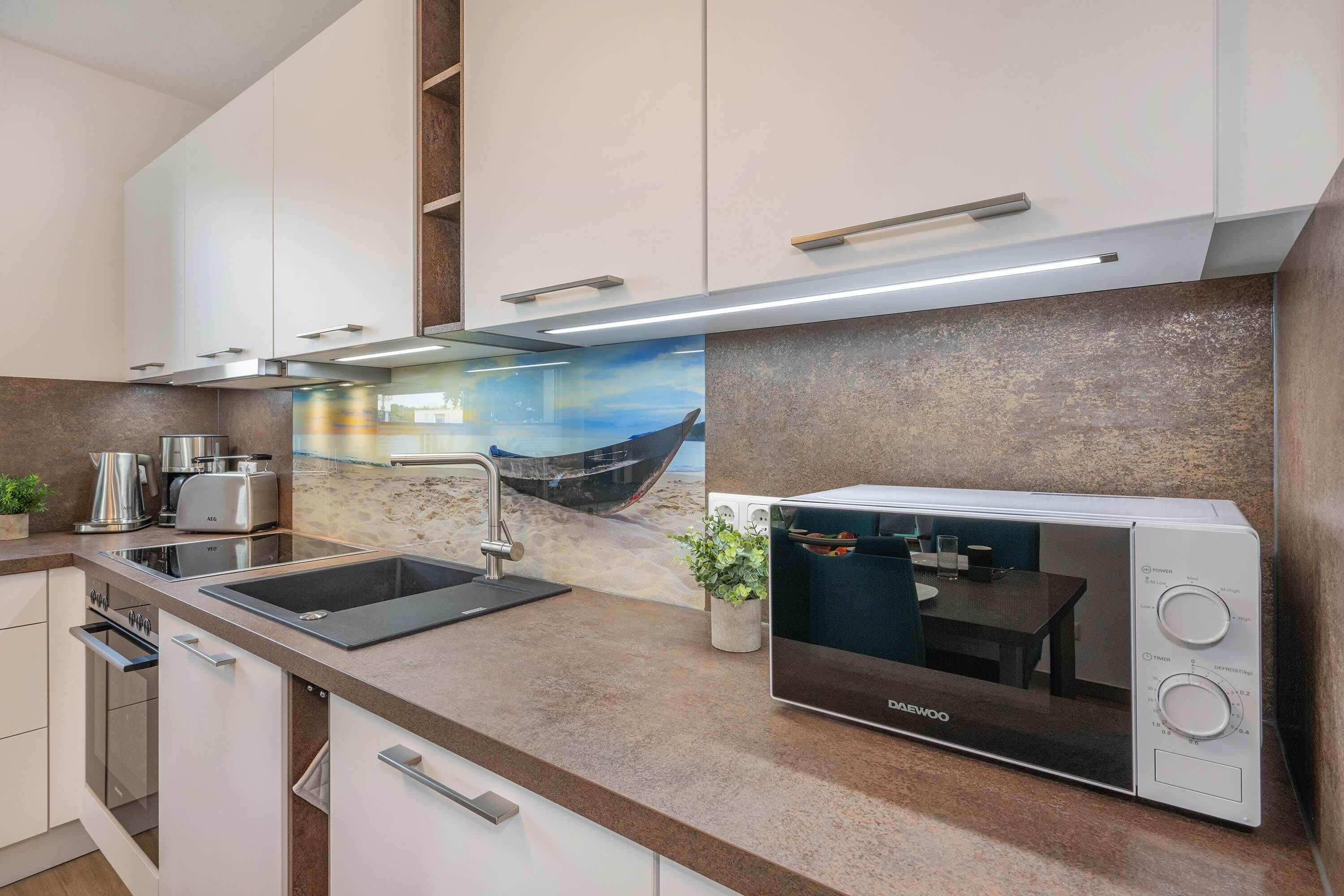 Una cocina moderna con horno empotrado, un lavamanos y una estufa.