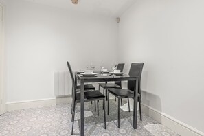 A dining area with a table set for four, including plates, glasses, and cutlery.