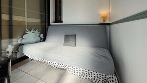 A small bedroom with a bed, a nightstand, a lamp, and a window with a view of the outside. - Pavilion with Sunny Terrace, Parking - Gruissan (Gruissan)
