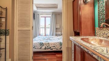 A bathroom with a sink, mirror, and patterned tiles.