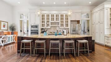 A spacious kitchen with a large island, bar stools, and modern appliances.