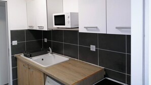Une cuisine moderne équipée d’un four à micro-ondes, d’un évier et de placards.