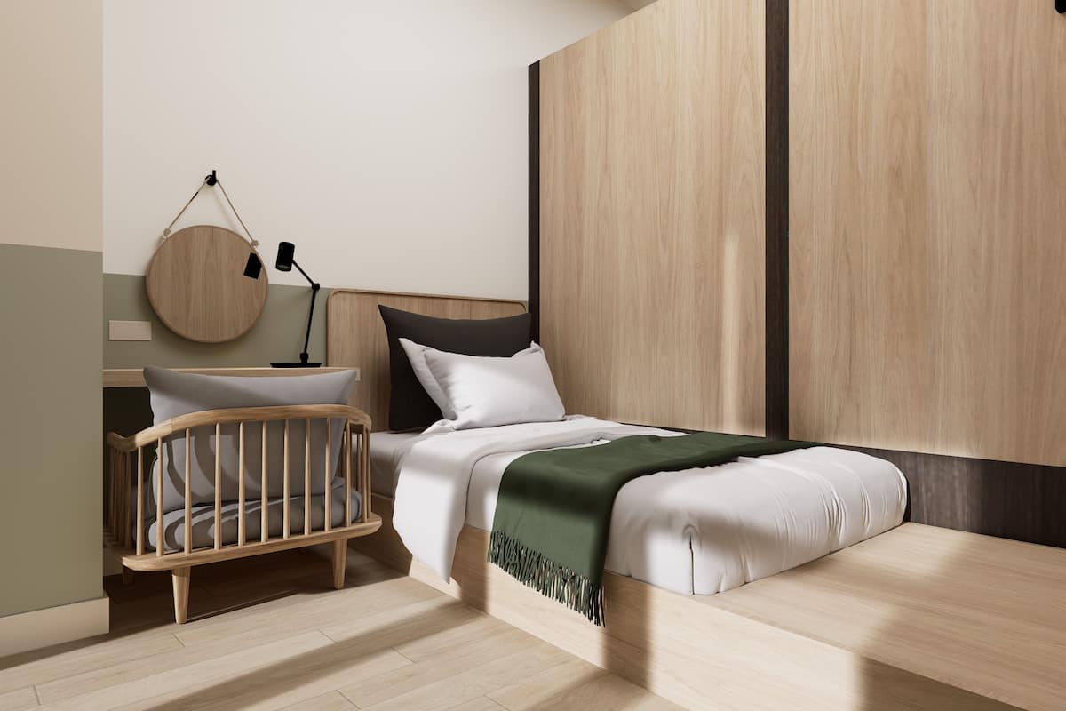 A modern bedroom with a wooden bed, a nightstand, a round mirror, and a crib.