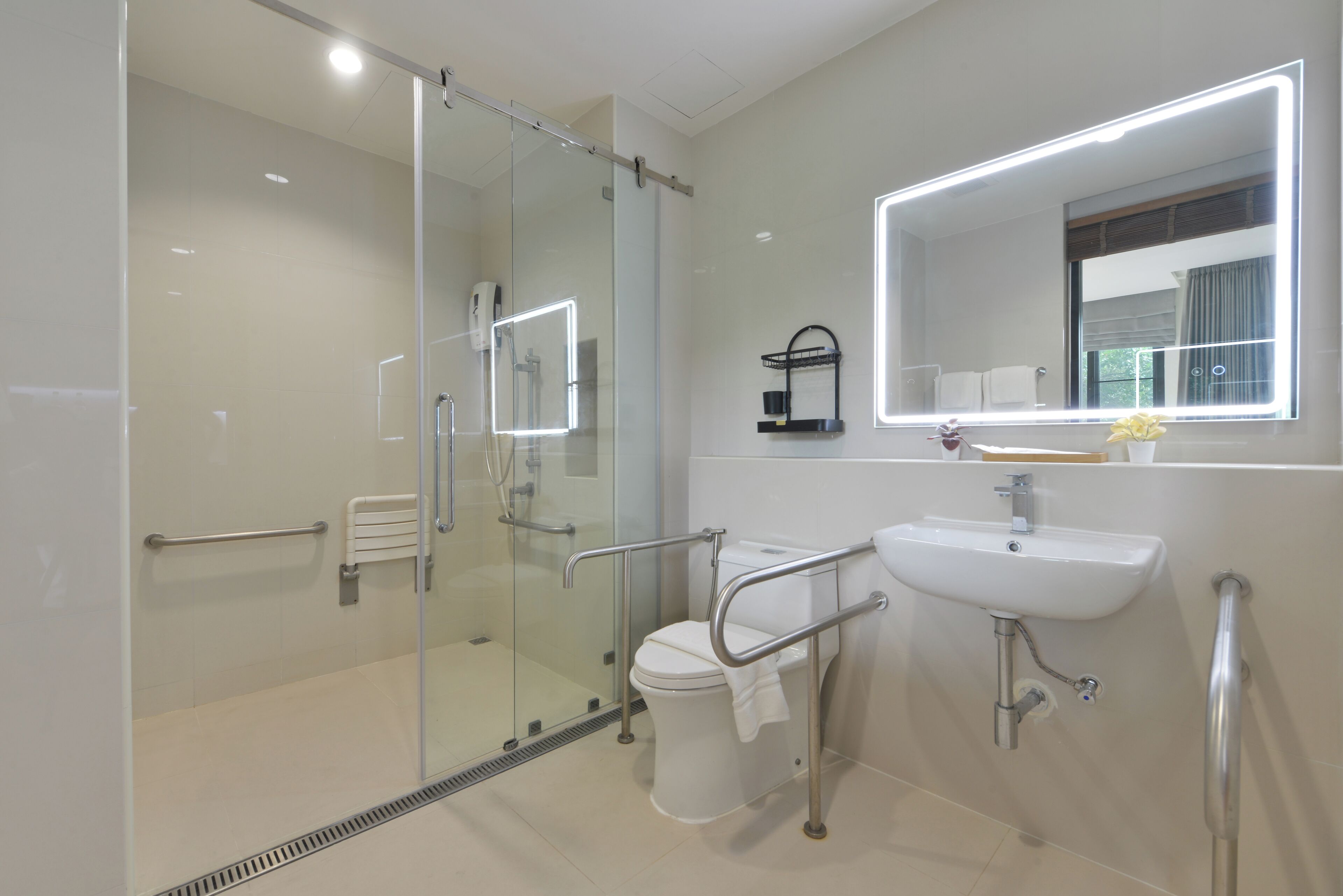 A modern bathroom with a glass shower enclosure, a white sink with a mirror, and a towel rack.