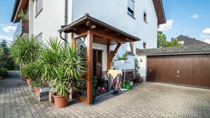 A house with a covered porch, potted plants, and a garage.