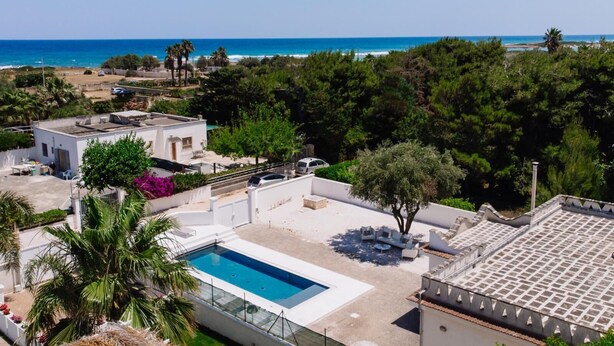 Zona residencial con piscina, patio amueblado y vista al mar.