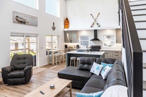 A modern living room with a sectional sofa, a coffee table, and a leather armchair.