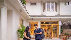 A courtyard with a café, a potted plant, and a bench. - Zostel Chennai Anna Nagar (Chennai)