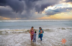 Escena de playa con cielo tormentoso y olas.