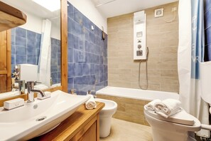 Departamento familiar, 1 habitación (Appartamento Alpine Inspiration) | Baño | Tina con regadera, secadora de cabello, bidet, toallas 