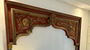 A decorative wall panel with intricate floral and leaf patterns, gold accents, and a classical design. - Chambre Rabaa   Dar Kbira (Tunis)
