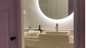 A bathroom with a white sink, a mirror, and a towel.