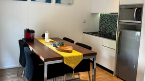 Una cocina moderna con una mesa de comedor, sillas y un refrigerador.