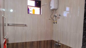 A bathroom with a shower, a sink, a towel rack, a soap dispenser, and a window with a view of the outside. - Charming 1-bedroom apartment with WiFi, AC in vibrant Goa (Goa)