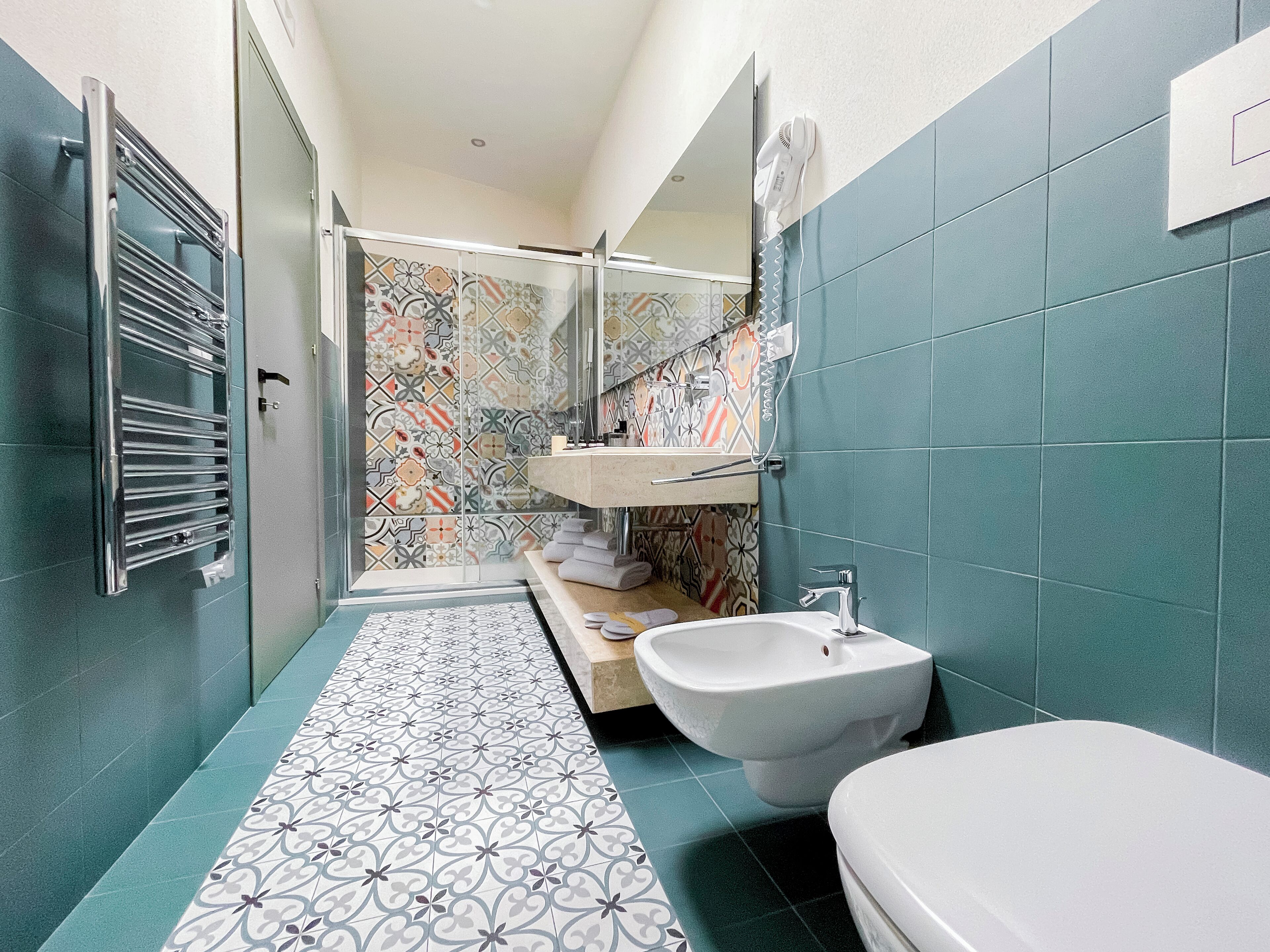 A bathroom with a shower, a sink, and a bidet.