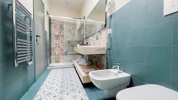 A bathroom with a shower, a sink, and a bidet.