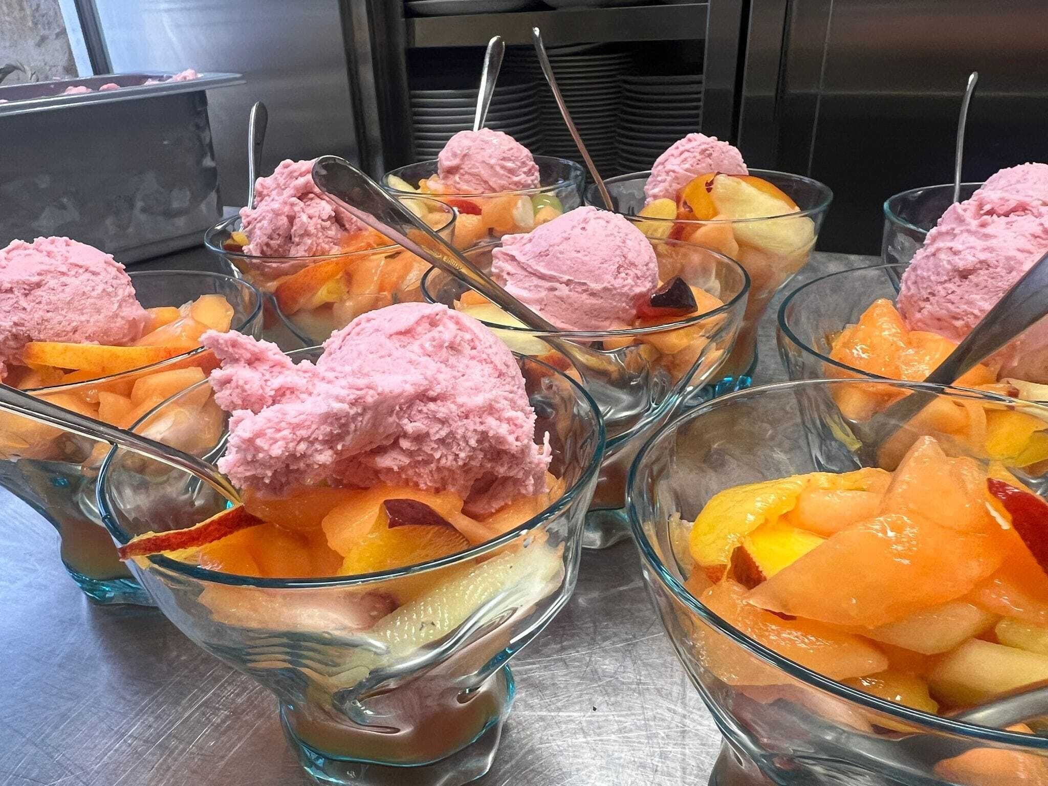 Dessert cups with pink ice cream and fruit.