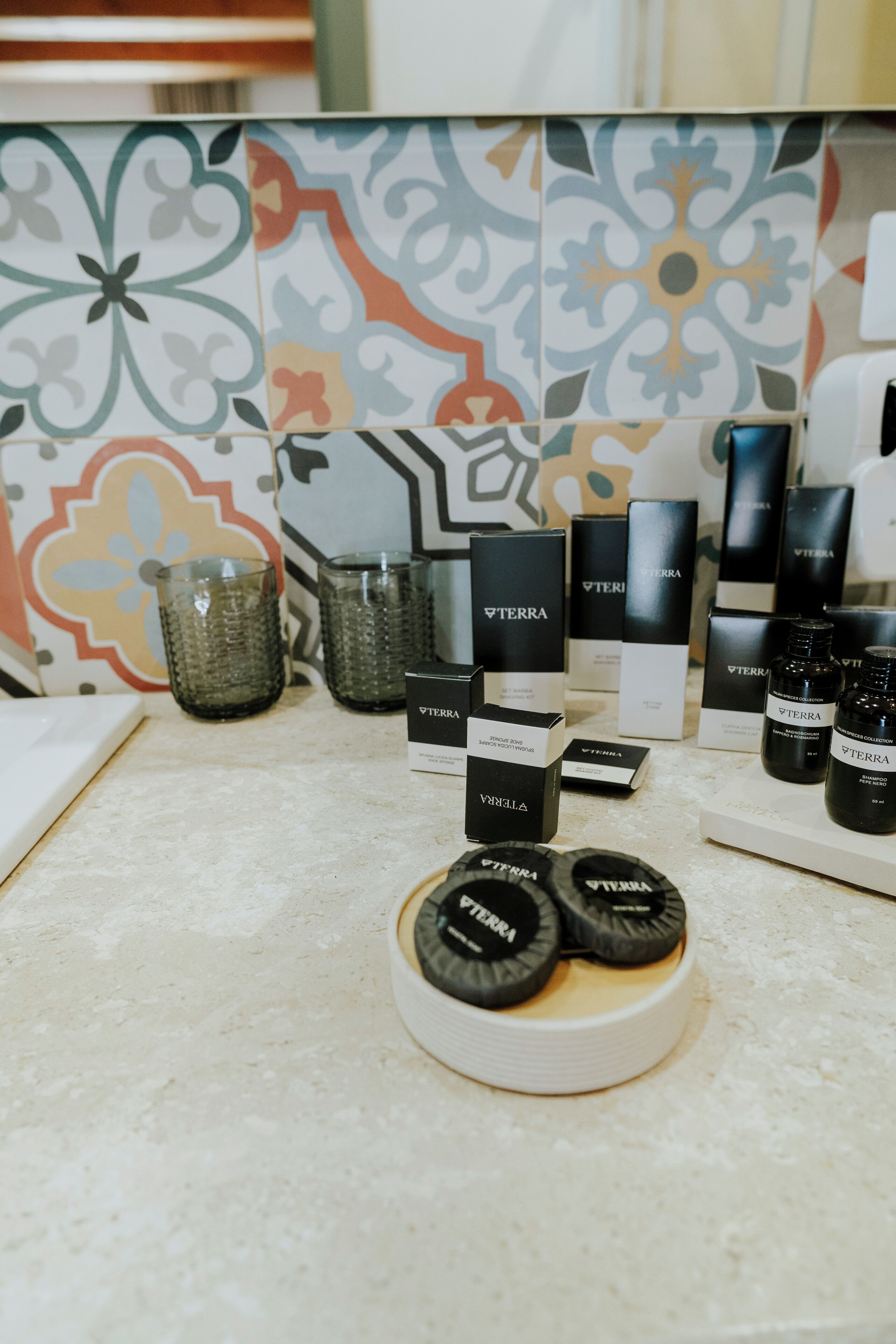 A countertop with various Terra brand products, including bottles and boxes, set against a colorful tiled backsplash.
