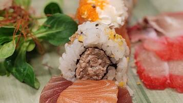 A plate with sushi rolls and sashimi.