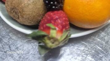 Un plat amb assortiment de fruites com freses, raïm, kiwi, taronja i mango.