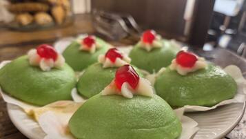 Een bord met groene dumplings en rode toppings, op een tafel gezet.