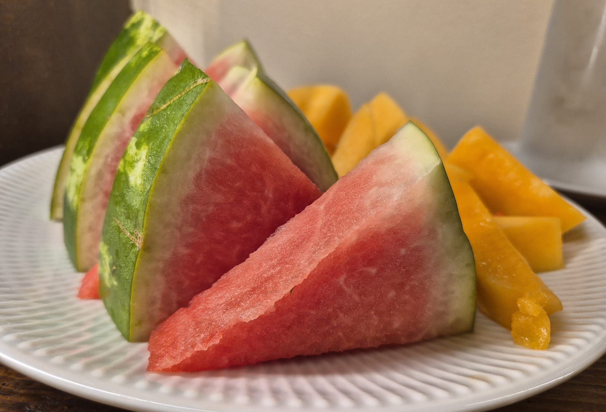 En tallerken med vandmelon i skiver og mango tern.