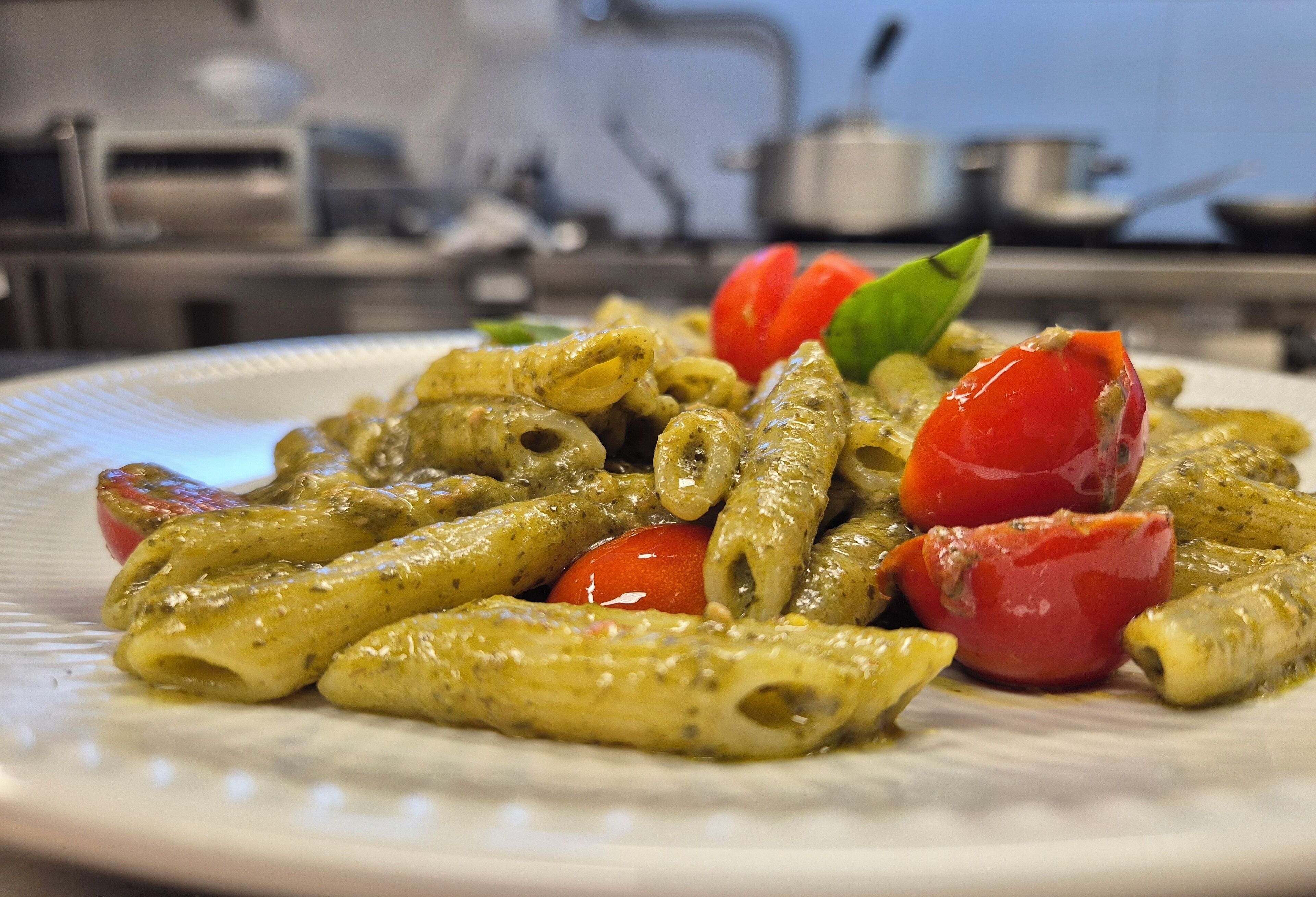 Un plato de pasta con tomates cherry y albahaca.