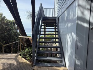 Eine Holztreppe führt zu einem Deck mit Blick auf den Ozean.
