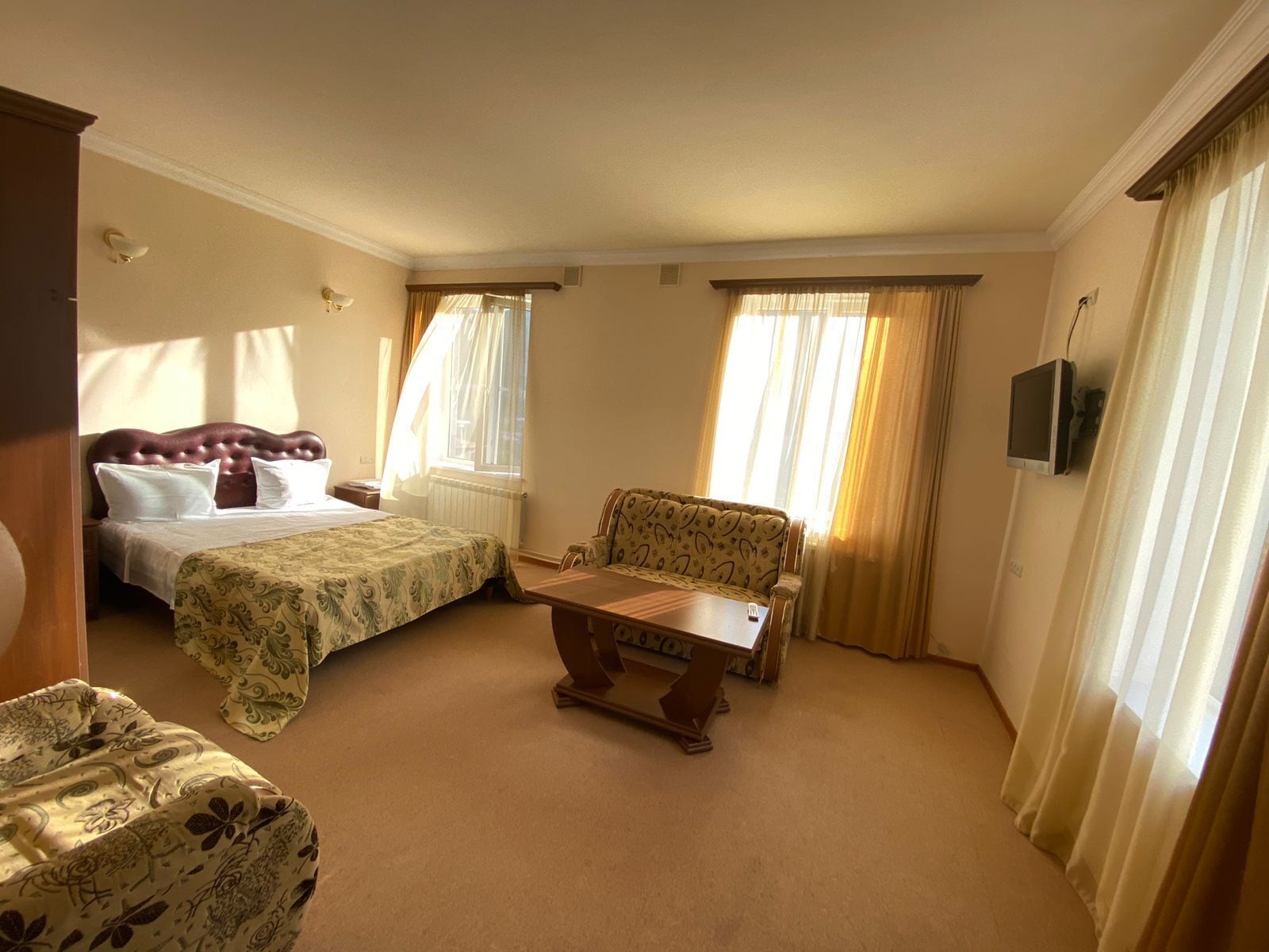 Una habitación de hotel con una cama, una silla, una mesita y un televisor.