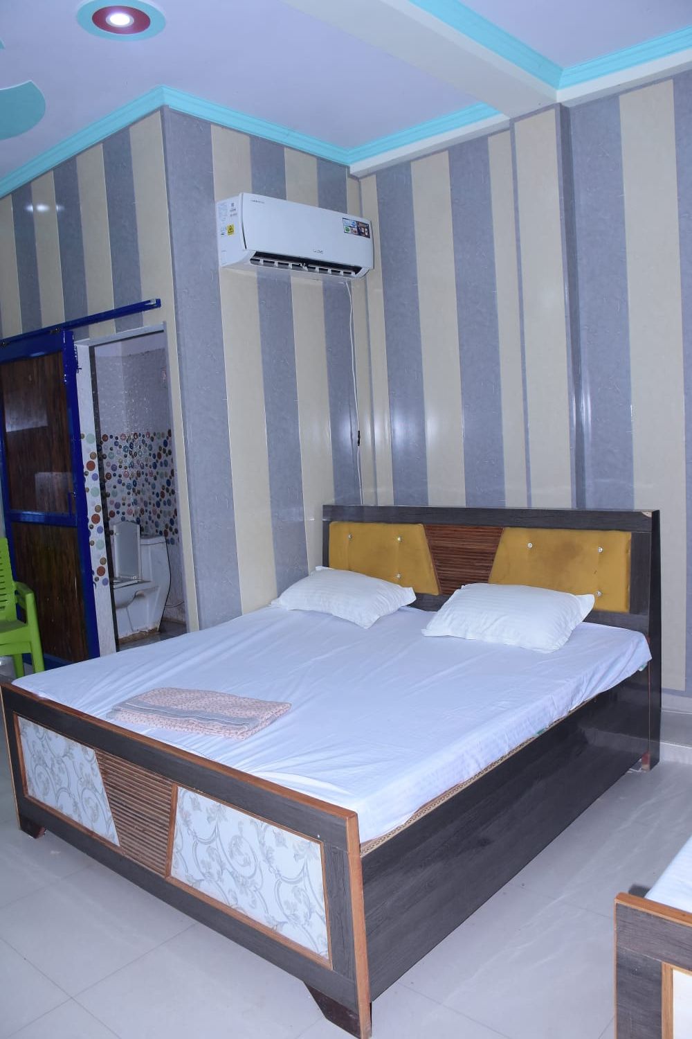 Een slaapkamer met een bed, een raam, een deur en een airconditioning.