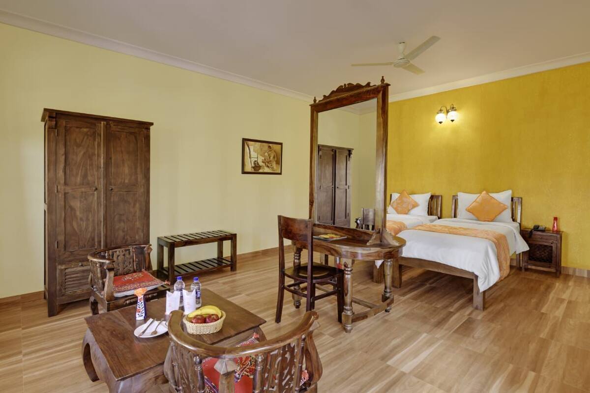 Una habitación con una cama, una silla, una mesa, un armario y un ventilador de techo, todos de madera.