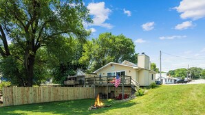 A house with a deck, a fire pit, and an American flag. - The Big Muddy Riverfront Bungalow (Princeton)