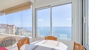 Un balcon avec une table et des chaises, offrant une vue sur la côte.