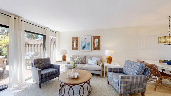 A living room with a sofa, two armchairs, a coffee table, and a dining area with a table and chairs. - Comfort and convenience! Short walk to the beach! (Hilton Head)