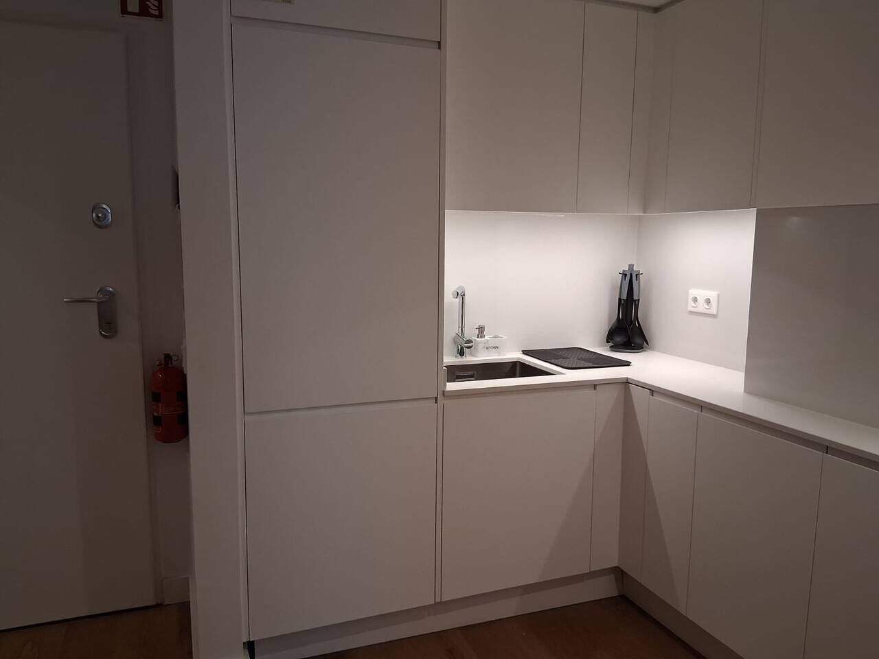 A compact kitchen with white cabinets, a sink, and a small countertop.