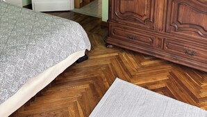 Une chambre à coucher comprenant un lit, une armoire et une porte donnant sur un couloir.