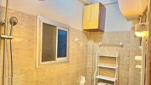 A bathroom with a shower, toilet, and sink.