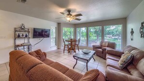 A living room with a ceiling fan, a TV, a dining table with chairs, and two sofas. - WW D101 Splish Splash (New Braunfels)