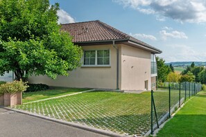 Une maison moderne avec un toit en tuiles, une fenêtre et une pelouse bien entretenue.