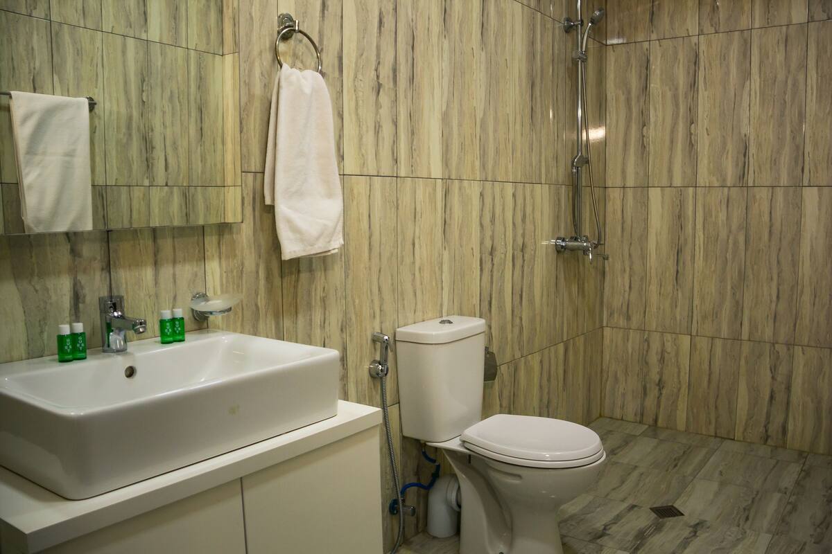 A bathroom with a sink, toilet, and shower.
