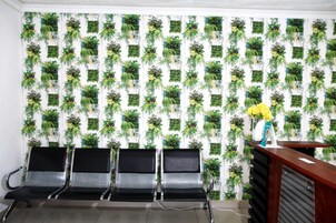 Un área de espera con una pared de jardineras verticales y un mostrador de recepción.