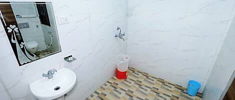 A bathroom with a white sink, a shower, and a mirror.