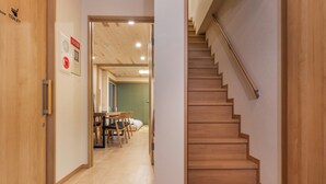 Una scala in legno conduce al secondo piano, una porta in legno con la scritta 