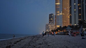 Une plage avec des immeubles de grande hauteur en arrière-plan.